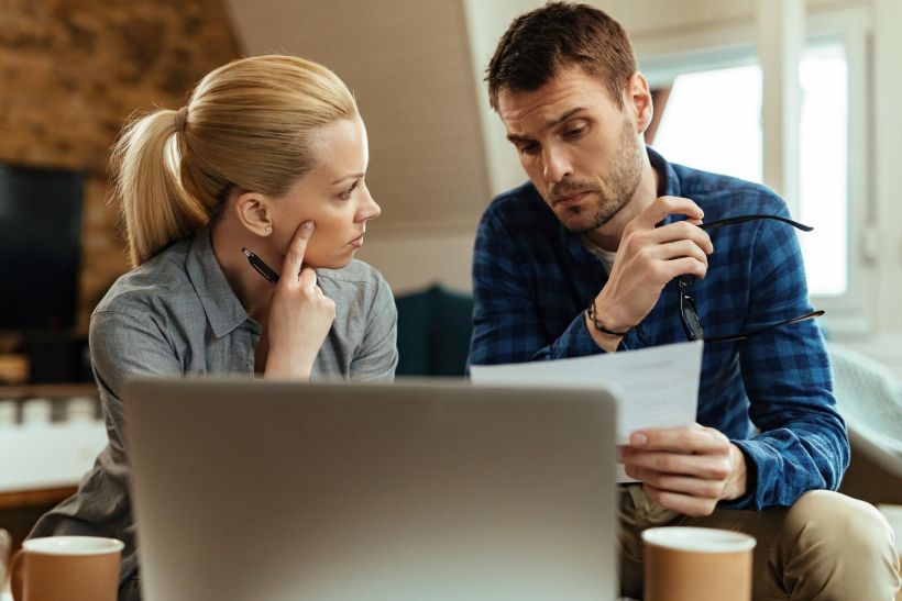 Young couple communicating while going through their car finances.
