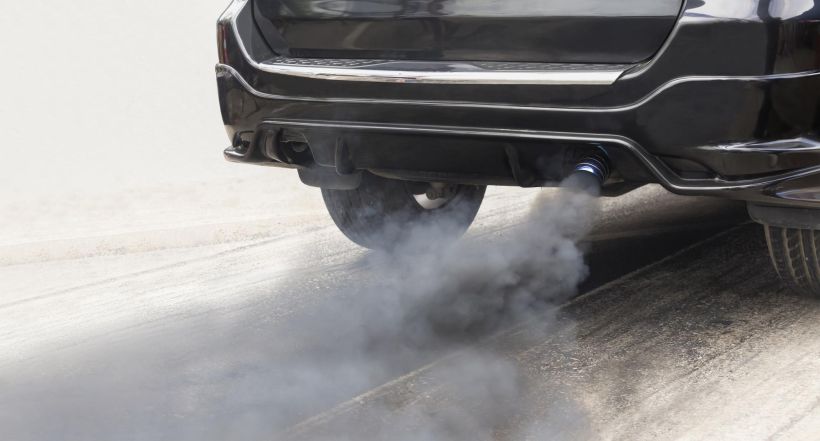 Air pollution crisis in city from diesel vehicle exhaust pipe on road.