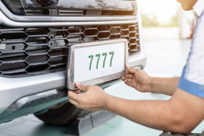 Technician changing car plate number in service center.
