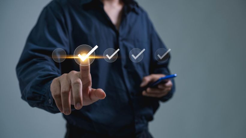 Businessmen tick the boxes for standardisation certification and quality control.