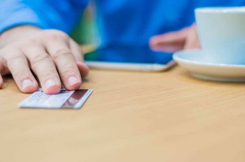 Hombre de negocios pagando con tarjeta de cr&eacute;dito o d&eacute;bito.