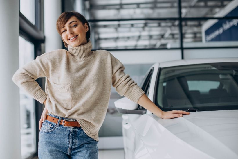 Mujer en un concesionario de coches eligiendo un coche nuevo.
