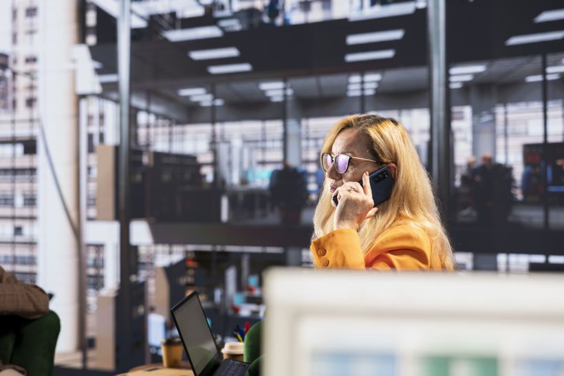 Una decidida mujer de negocios hablando por tel&eacute;fono para garantizar el desarrollo del proyecto.
