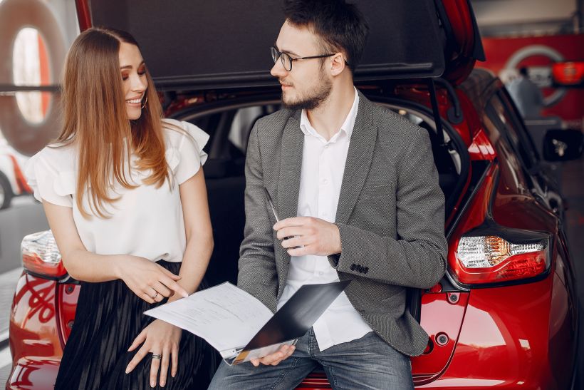 Mujer elegante y con estilo en un sal&oacute;n de autom&oacute;viles.