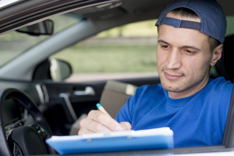 Joven firmando un documento.
