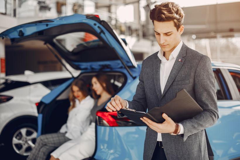 Dos mujeres elegantes en un salón de automóviles.