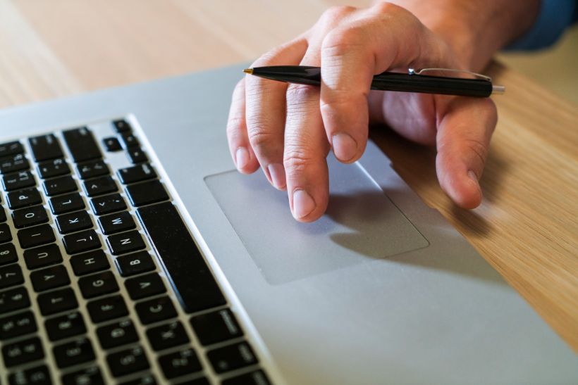 Una persona de negocios escribiendo en un ordenador port&aacute;til.