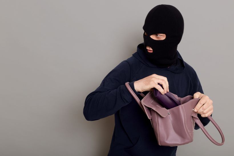 Perfil de un ladrón con el rostro enmascarado.