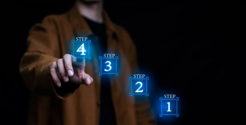 Un empresario sostiene una pila de hologramas que representan el crecimiento paso a paso del negocio a medida que avanza el personal.