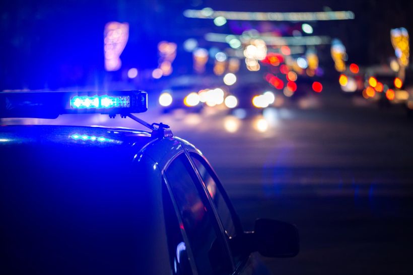 Luces de un coche de polic&iacute;a por la noche en la ciudad con enfoque selectivo.
