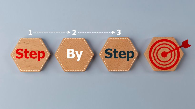 An illustration of a business concept with wooden cubes, on which step-by-step instructions are written.