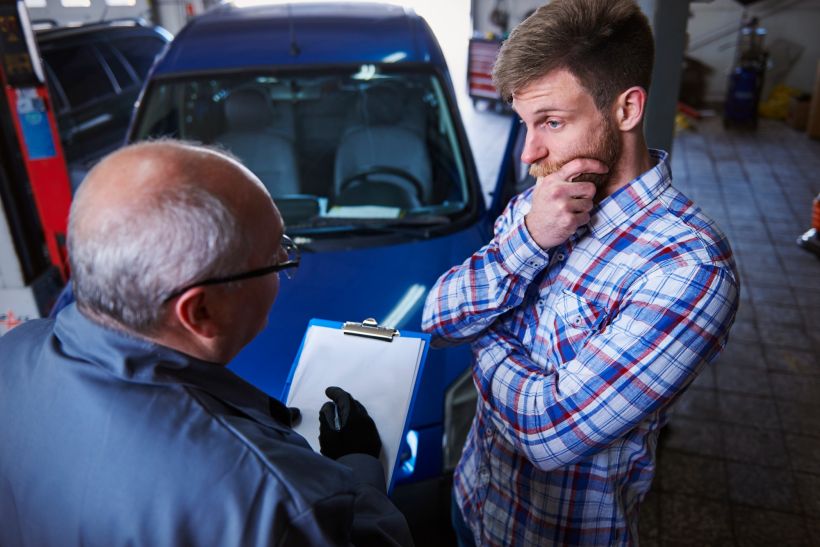El cliente habla con el mec&aacute;nico en el taller de autom&oacute;viles.