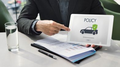 A man points to an auto insurance policy for a vehicle with a salvage titA man points to an auto insurance policy for a vehicle with a salvage title Californiale California