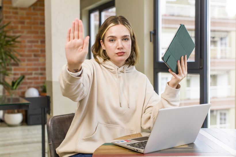 Pretty young woman with a laptop ask to stop.