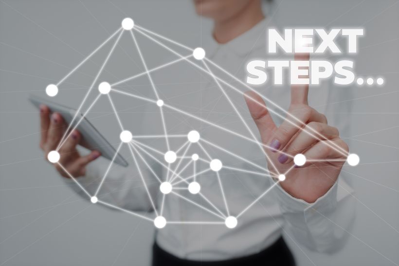 Low angle view of man using mobile phone with words &ldquo;Next Steps&rdquo;.